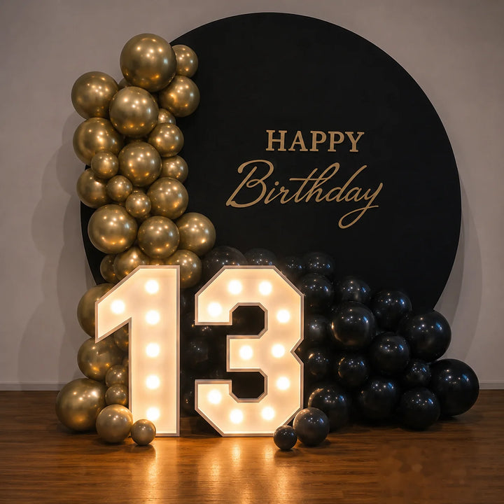 Illuminated marquee number 13 displayed with a black and gold balloon arrangement and elegant birthday backdrop, creating a luxury setup for a 13th birthday party, teen celebration, event rental, and photo booth décor.