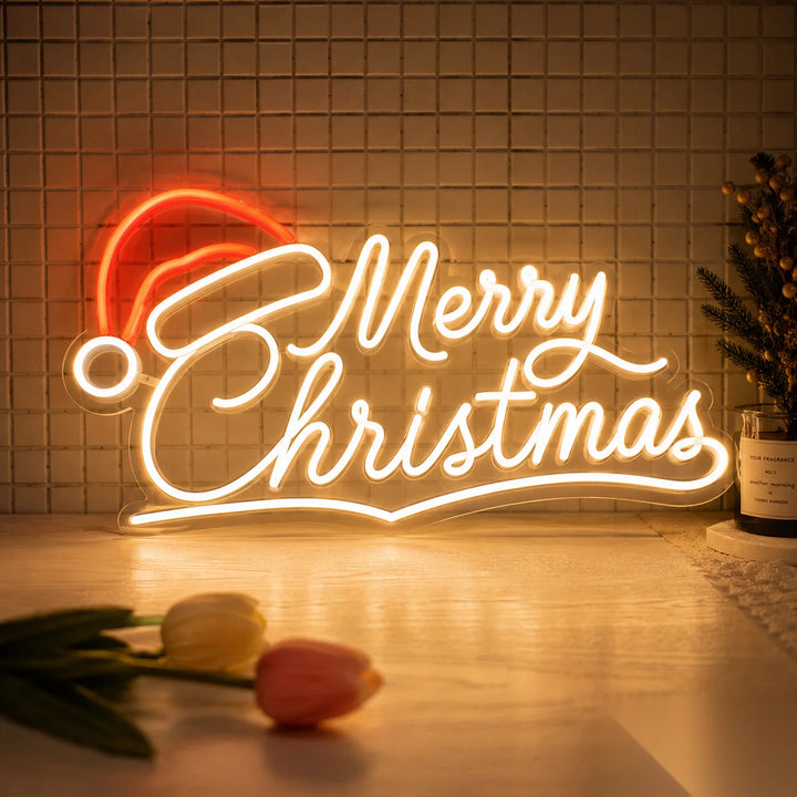 Acrylic LED neon sign featuring Merry Christmas lettering with Santa hat and warm white lighting for cozy holiday home decor and Christmas tabletop styling.