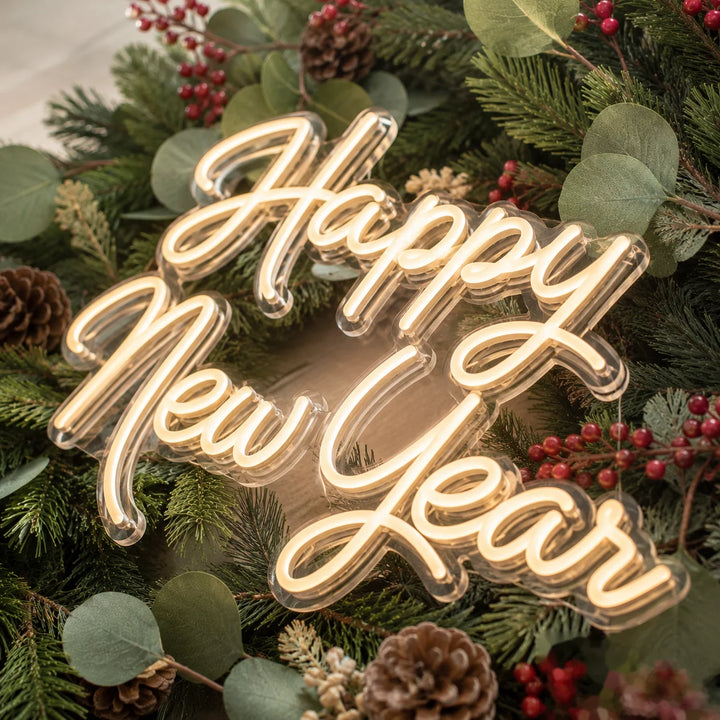 Acrylic LED neon sign featuring Happy New Year script with warm white lighting surrounded by pine wreath, berries, and festive holiday greenery for Christmas and New Year home decor.