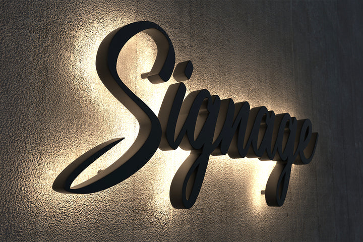 Custom 3D backlit LED sign spelling Signage with warm white light on dark wall.
