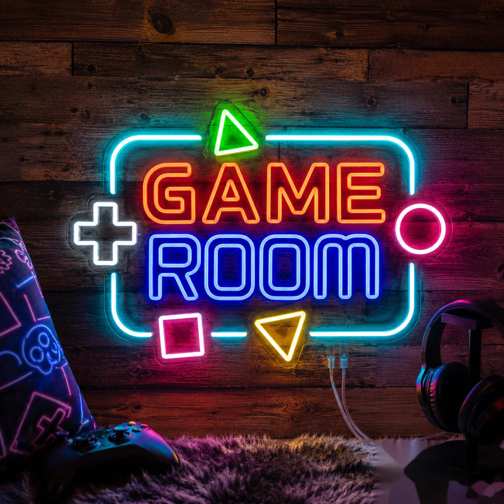 Colorful “Game Room” neon wall light with gaming-inspired symbols displayed in a cozy gamer bedroom featuring headphones, controller, and RGB atmosphere lighting.