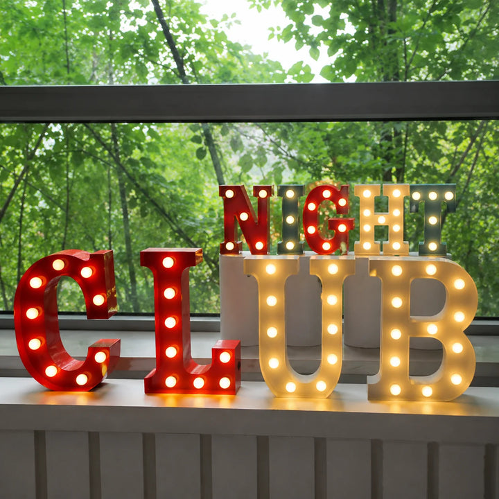 Colorful illuminated CLUB and NIGHT marquee letter signs displayed in front of a large window with forest views, creating a vibrant atmosphere for bars, clubs, parties, entertainment venues, and event décor.