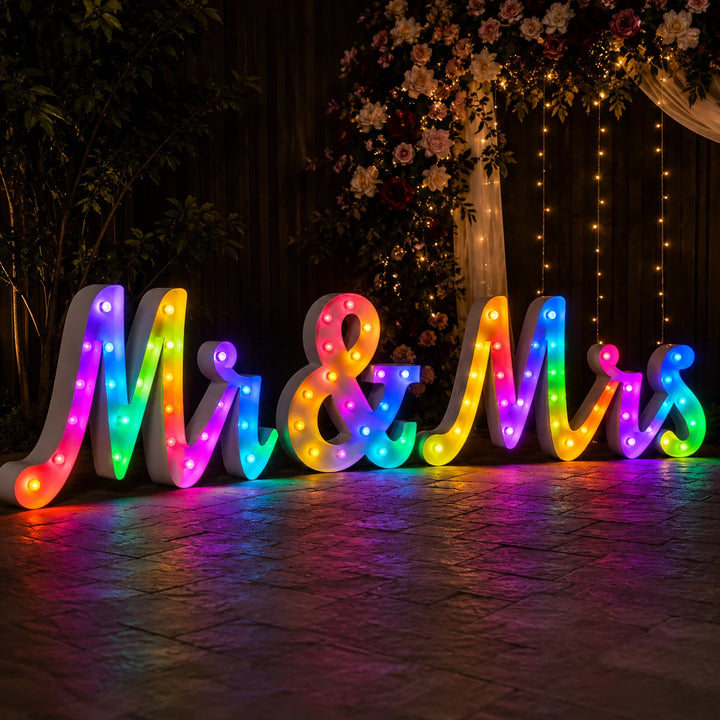 Colorful RGB illuminated Mr & Mrs marquee letter sign with multicolor LED lighting for luxury wedding reception, engagement party, and romantic nighttime event backdrop.