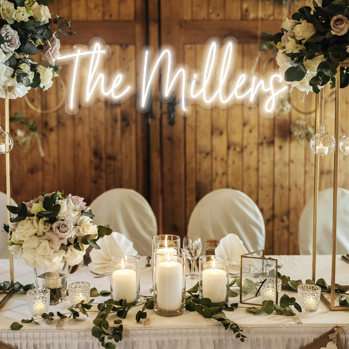 Decorated table with candles and flowers, featuring a neon sign with &